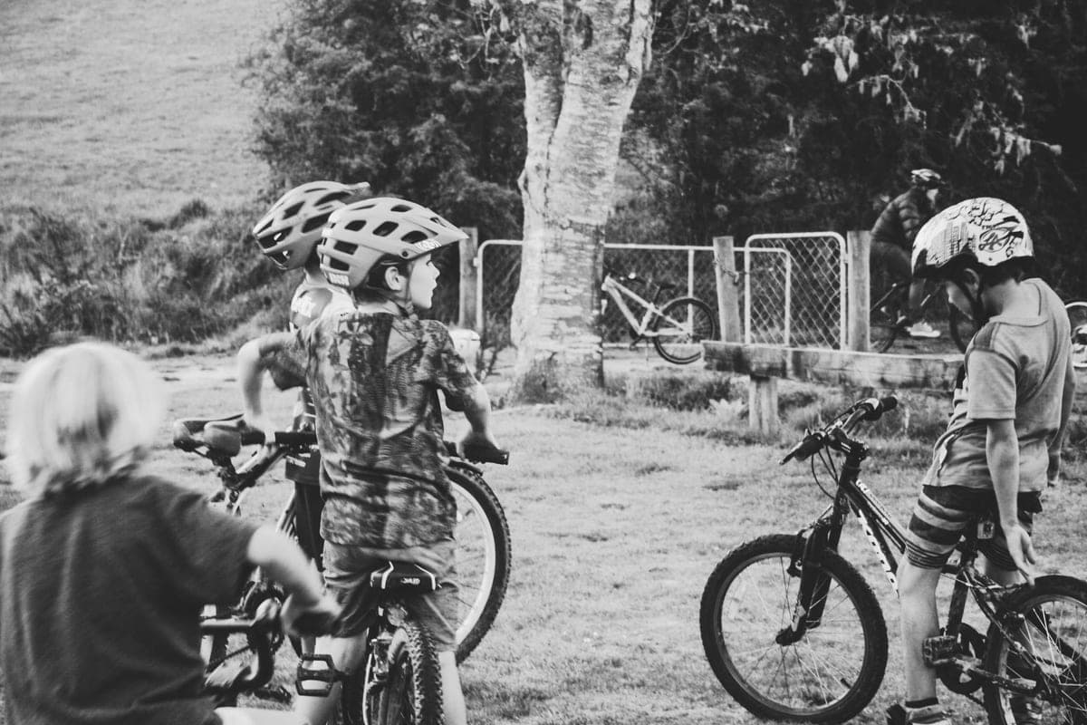 Group of helmeted children standing with their bikes